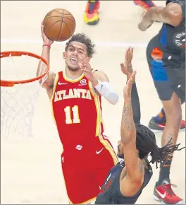  ?? TODD KIRKLAND — GETTY IMAGES ?? The Hawks’ Trae Young, who had 21 points, goes up for a shot and is fouled by the Knicks’ Derrick Rose during Game 3 of the Eastern Conference first-round playoff series.