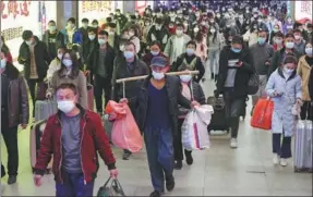  ?? HU JINLI / FOR CHINA DAILY ?? Above: Travelers return to the city at Wuhan Railway Station on Feb 17 after the Spring Festival holiday.