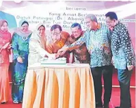  ??  ?? GENAP SETAHUN: Abang Johari meniup lilin simbolik genap setahun sebagai Ketua Menteri sambil disaksikan tetamu kehormat lain.