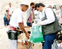  ??  ?? KSRelief personnel distribute aid packets among the needy in Yemen. (SPA)