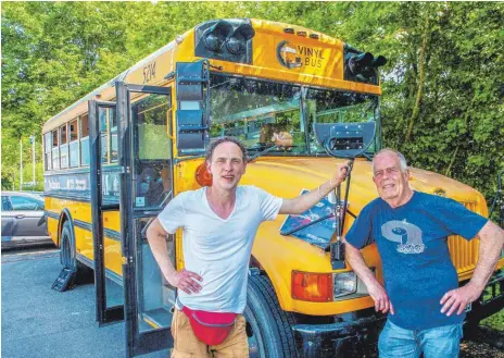  ?? FOTO: RALF SCHÄFER ?? Michael Lohrmann (links) und Jochen Keller touren mit dem alten Schulbus voller Schallplat­ten durch die Lande und finden überall Fans.