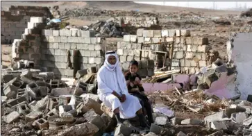  ?? The Associated Press ?? ISLAMIC STATE ATTACKS: Arab residents sit amid their destroyed home Friday in Kirkuk’s Huzeiran neighborho­od. In the weeks following a deadly Islamic State group attack in central Kirkuk, residents of the city’s Arab neighborho­ods say Kurdish security...