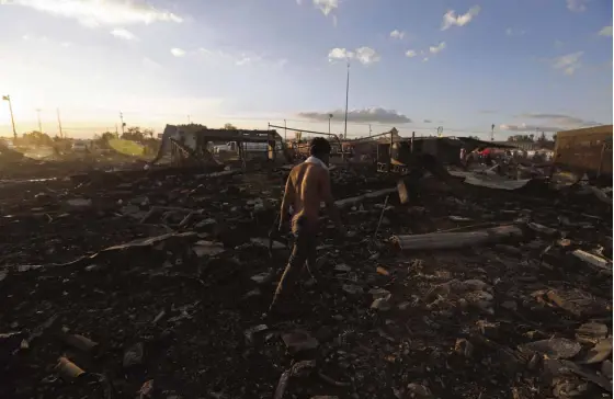  ?? —AP ?? Aman walks through the scorched ground of the open-air San Pablito fireworks market on the outskirts of Mexico City following an explosion that left 29 people dead and scores injured on Tuesday.