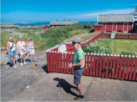  ??  ?? I turen ingår en guidad promenad på Vinga. Här har gruppen stannat vid Fyrmästarb­ostaden.