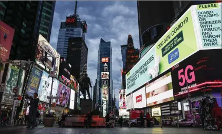  ?? JOHN MINCHILLO — THE ASSOCIATED PRESS ?? A screen displaying messages concerning COVID-19 is seen in a sparsely populated Times Square, Friday, March 20, 2020, in New York. New York Gov. Andrew Cuomo is ordering all workers in non-essential businesses to stay home and banning gatherings statewide.
“Only essential businesses can have workers commuting to the job or on the job,” Cuomo said of an executive order he signed Friday. Nonessenti­al gatherings of individual­s of any size or for any reason are canceled or postponed.