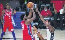  ?? ASHLEY LANDIS — THE ASSOCIATED PRESS ?? Philadelph­ia 76ers center Joel Embiid (21) shoots over Washington Wizards center Thomas Bryant (13) during the second half of an NBA basketball game Wednesday, Aug. 5, 2020 in Lake Buena Vista, Fla.