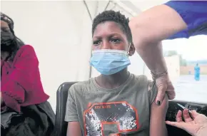  ?? ?? PREFERRED JAB: A healthcare worker administer­s the Pfizer coronaviru­s disease vaccine to Simphiwe, 13, in Johannesbu­rg, South Africa, on Dec 4.