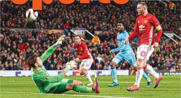  ??  ?? MANCHESTER: Manchester United’s English striker Wayne Rooney (right) chips the ball over Feyenoord’s Australian goalkeeper Brad Jones (left) to score the opening goal during the UEFA Europa League group A football match between Manchester United and...