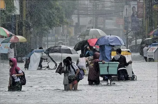  ?? TED ALJIBE / AFP ?? Calles inundadas el mes de agosto en Manila, en Filipinas, donde cientos de personas mueren cada año por los desastres climáticos