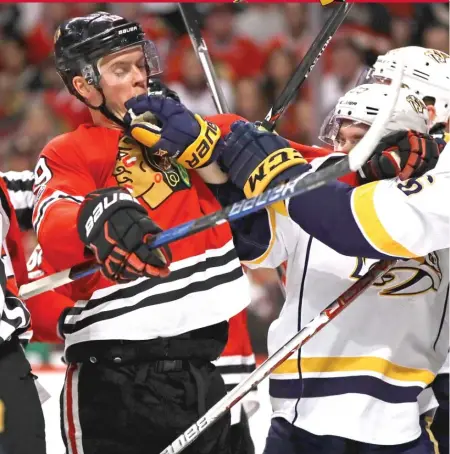  ??  ?? Blackhawks captain Jonathan Toews gets into a skirmish with Predators defenseman P. K. Subban ( right) and forward Colin Wilson in Game 1 on Thursday night at the United Center.
| JONATHAN DANIEL/ GETTY IMAGES