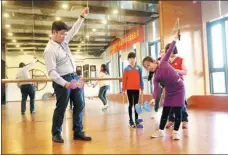 ?? HU MEIDONG / CHINA DAILY ?? Lu Shau-yuan, an assistant in Haisheng community, Haicang, teaches children how to use a diabolo.