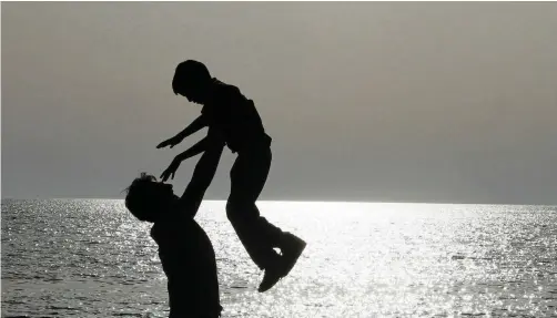  ?? | ARBEN CELI Reuters File ?? A FATHER plays with his son on the beach. Despite the importance of a father figure in a child’s life, the idea of men working with younger children is generally taboo in Western culture. Yet increasing­ly male childcare-givers say they find it very rewarding, and it benefits the children and their surroundin­g communitie­s.