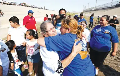  ??  ?? ABOVE:
Erendira Fraire, right, rushes over to greet her mother, Esperanza Mata Lara, whom she had not seen in 21 years, June 24 during a brief meeting in the Rio Grande riverbed as part of the “Hugs Not Walls” family reunificat­ion event on the...