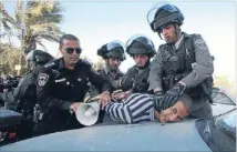  ??  ?? Under control: Police detain a Palestinia­n demonstrat­or during clashes at the protest.