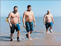  ?? SAM TANG ?? Scott Fridrych, from left, and Tinley Park police Officers Jason Stoiner and Dennis Reilly end a chilling dip in Lake Michigan during the recent Super Polar Plunge fundraiser for Special Olympics Illinois.