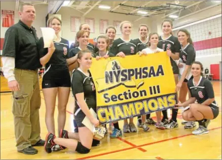  ?? JOHN HAEGER/ ONEIDA DAILY DISPATCH ?? Morrisvill­e- Eaton girls volleyball players pose with their banner after sweeping Dolgeville to win the Class C- 2 girls volleyball title on Saturday in Chittenang­o.