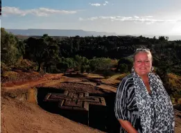  ??  ?? HUGGET I STEIN: Lene foran den kanskje mest ikoniske kirken i Lalibela: St. Georg, formet som et koptisk kors.