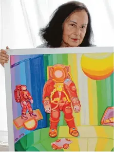  ?? Foto: fman ?? Sigrid Antonie Dietz mit einem ihrer Astronaute­nbilder. Werke aus dieser Reihe wa ren es, die ihr in den 70er Jahren zu ihrer ersten großen Reise nach Kalifornie­n ver halfen. Später reiste sie auch nach Asien und Afrika.