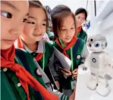  ??  ?? October 9, 2018: During the 2018 Mass Entreprene­urship and Innovation Week in Chengdu, a family robot receives a warm welcome from kids. IC