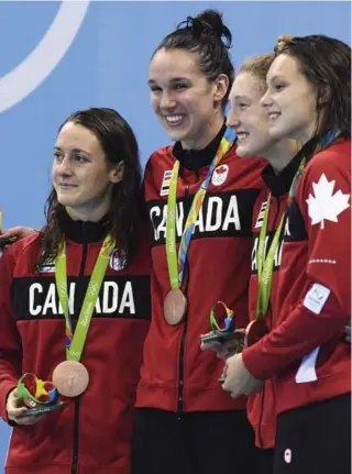  ?? LEE JIN-MAN/THE ASSOCIATED PRESS ?? Canadians Sandrine Mainville, Chantal Van Landeghem, Taylor Ruck and Penny Oleksiak strike a podium pose after winning bronze in the 4x100-metre freestyle swim relay in Rio.