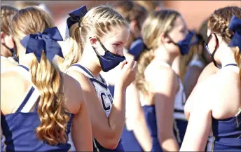  ?? — AFP photo ?? An Irish cheerleade­r adjusts her mask before a game in Westfield, Indiana. WHO says data indicates that teenagers may play a more active role in virus transmissi­on than children.