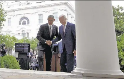  ?? CAROLYN KASTER/ASSOCIATED PRESS ?? After President Barack Obama’s remarks Thursday in the White House Rose Garden about the U.S. Supreme Court upholding subsidies for the Affordable Care Act, he and Vice President Joe Biden shake hands as they head back to the Oval Office.