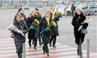  ?? EFREM LUKATSKY THE ASSOCIATED PRESS ?? A crew of a Ukrainian airline carries flowers to pay tribute to the flight crew members of the Ukrainian 737-800 plane that crashed on the outskirts of Tehran.