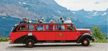  ?? Fotos (2): Christian Röwekamp, tmn ?? Durchs offene Verdeck die spektakulä­re Bergwelt betrachten: Die roten Busse im Glacier Nationalpa­rk in Montana haben Platz für bis zu 17 Passagiere.