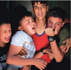  ?? — Reuters ?? Relatives of a Palestinia­n, who was killed at the Israel-gaza border, react at a hospital in Gaza City.