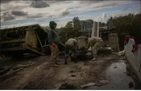  ?? FRANCISCO SECO — THE ASSOCIATED PRESS ?? Ukrainian soldiers remove metal pieces as they work on a bridge damaged during fighting with Russian troops in Izium, Ukraine, on Monday.