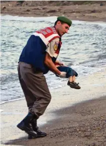  ?? AP ?? Der Polizist Mehmet Ciplak trägt den toten Aylan weg.