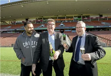  ??  ?? Liam Messam, Dallas Fisher and Hamilton Mayor Andrew King pop the champagne to celebrate Hamilton’s winning sevens bid.