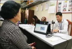  ?? PHA LINA ?? An official processes a person’s identifica­tion card at a voter registrati­on office in Phnom Penh earlier this month.