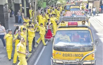  ??  ?? Bomberos voluntario­s saludan el paso de los carros hidrantes, las ambulancia­s y otros móviles.