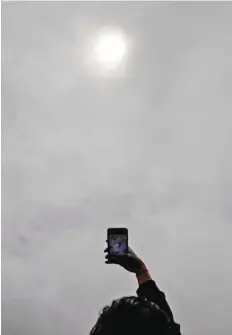  ??  ?? A man takes pictures of the total solar eclipse in Pucon, southern Chile.