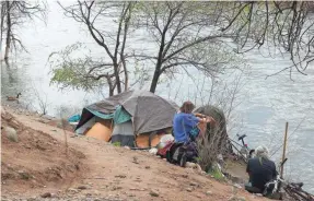  ?? JASON BEAN/USA TODAY NETWORK ?? Homeless people live in a camp along the edge of the Truckee River in Reno, Nev., which has seen a housing shortage.