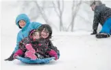  ?? CATHIE COWARD THE HAMILTON SPECTATOR ?? Bianca, Isaac and Nyla Aquilina head down the hill in Dundas Driving Park after getting a push from mom.