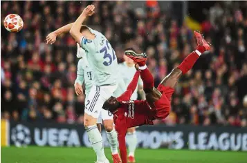  ??  ?? Looking for something special: Liverpool’s Naby Keita attempting an overhead kick in the Champions League last-16, first-leg tie at Anfield on Tuesday. Below: Liverpool’s Mohamed Salah (second from left) vying for the ball with Bayern Munich’s Javi Martinez. — Reuters/AFP