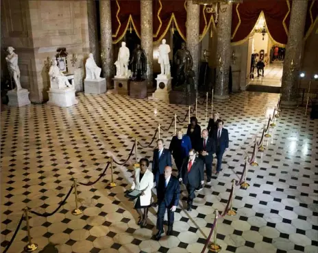  ?? Doug Mills/The New York Times ?? House impeachmen­t managers, led by the Clerk of the House Cheryl Johnson and House Sergeant at Arms Paul Irving, walk from the House through Statuary Hall on Wednesday to deliver the articles of impeachmen­t to the Senate in Washington.