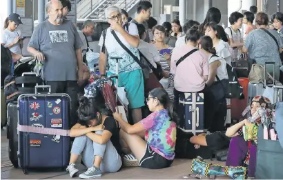  ?? AFP ?? Passengers stranded overnight at the Kansai airport due to typhoon Jebi wait for transport out of the airport in Izumisano city. —