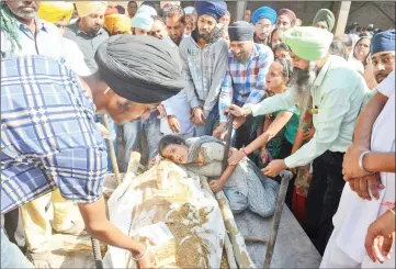  ?? — AFP photo ?? Jasbir Kaur (bottom centre), wife of Balbir Singh, who was killed when a train ploughed into a crowd of revellers, cries during a cremation ceremony in Amritsar.
