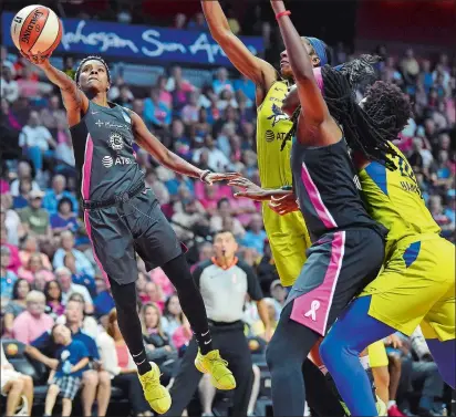  ?? SARAH GORDON/THE DAY ?? Connecticu­t Sun guard Courtney Williams, left, puts up a shot during the second half of Sunday’s WNBA game against the Dallas Wings at Mohegan Sun Arena. The Sun won 78-68. Please go to theday.com to view a photo gallery from the game.