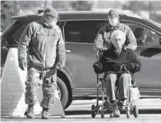  ?? ROBERT F. BUKATY/AP ?? National Guardsmen help a patient at a COVID-19 vaccinatio­n site Friday in Augusta, Maine.