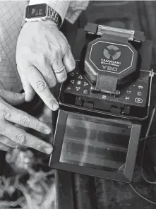  ??  ?? Weston Martinez and David Flores demonstrat­e a fusion splicer, used to connect optical fibers, at a ranch in Atascosa County.