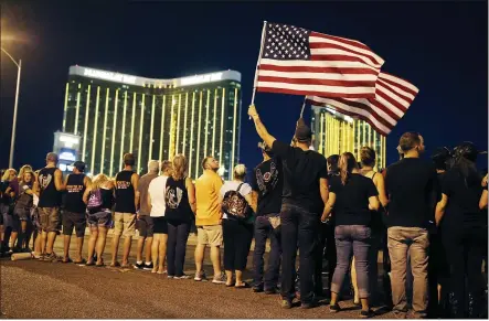  ?? PHOTOS BY JOHN LOCHER — THE ASSOCIATED PRESS FILE ?? People form a human chain around the shuttered site of a country music festival where a gunman opened fire on the first anniversar­y of the mass shooting in Las Vegas.