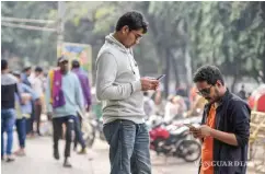  ?? ?? Dos personas revisan sus celulares en la Universida­d de Dhaka, Bangladesh. Con un deepfake, la imagen de un candidato se puede distorsion­ar.