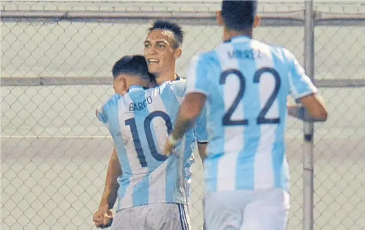  ?? AFP ?? El alivio merecido. Ezequiel Barco, de Independie­nte, abraza a Lautaro Martínez, deRacing, el autor del gol del justo empate. Se suma Ramón Mierez, de Tigre, al festejo.