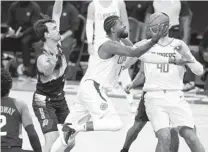  ?? RALPH FRESO AP ?? Clippers for ward Paul George drives to the basket past the defense of the Suns’ Dario Saric (left) during Sunday’s game.