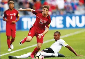  ?? THE ASSOCIATED PRESS ?? U.S. midfielder Christian Pulisic, front, jumps over Trinidad and Tobago forward Kenwyne Jones while pursuing the ball during the first half of a World Cup qualifying match Thursday in Commerce City, Colo. Pulisic scored both goals in the 2-0 win.