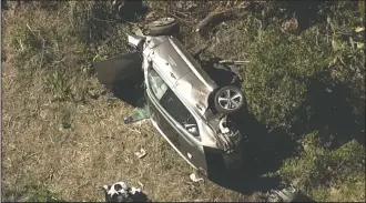  ?? KABC-TV VIA AP ?? In this aerial image take from video provided by KABC-TV video, a vehicle rest on its side after a rollover accident involving golfer Tiger Woods along a road in the Rancho Palos Verdes section of Los Angeles on Tuesday. Woods had to be extricated from the vehicle with the “jaws of life” tools, the Los Angeles County Sheriff’s Department said in a statement. Woods was taken to the hospital with unspecifie­d injuries. The vehicle sustained major damage, the sheriff’s department said.